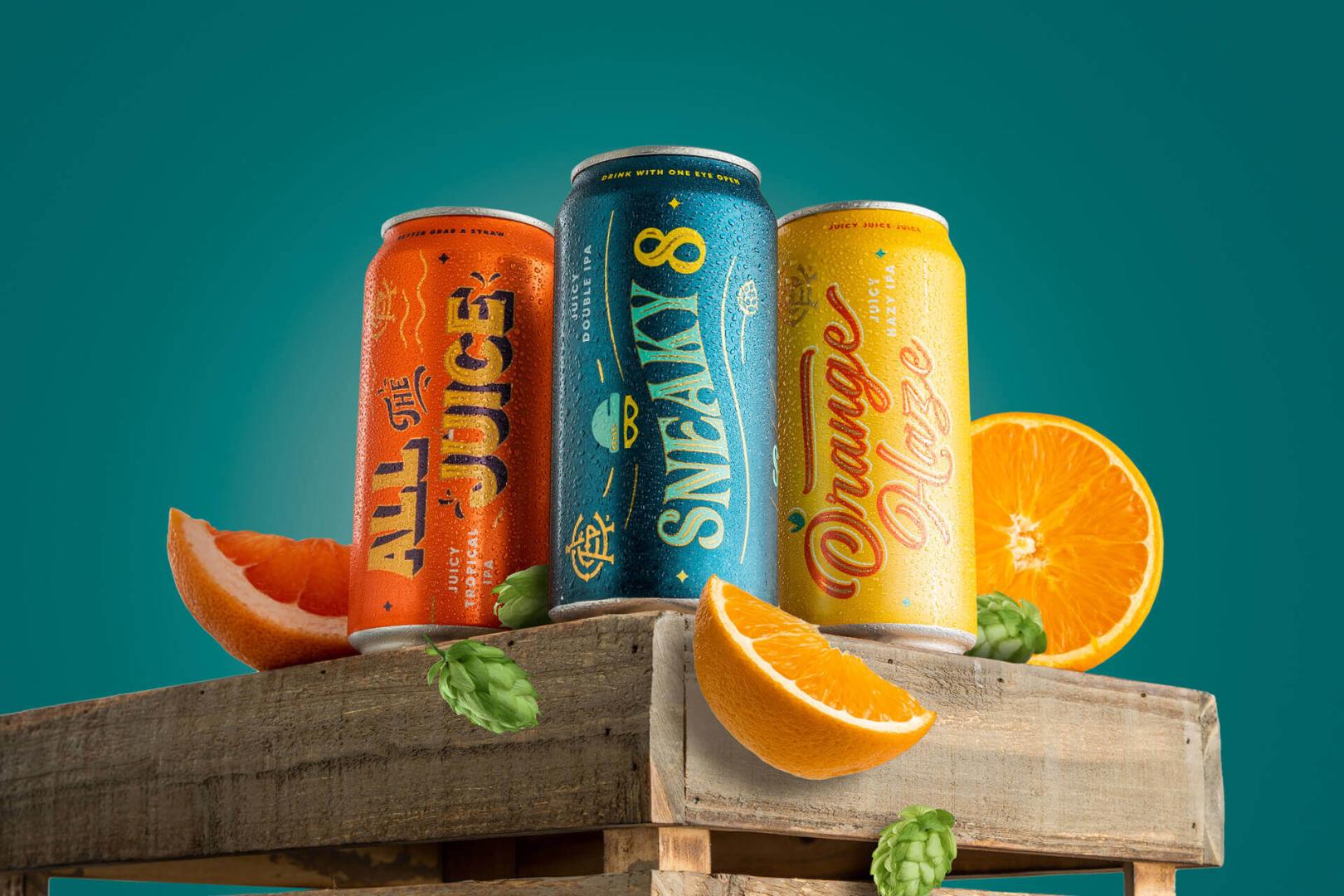 Can of AC golden beers in wooden box with cut orange fruit